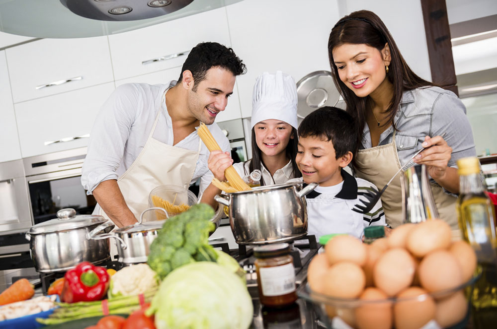 Família cuinant a la seva llar