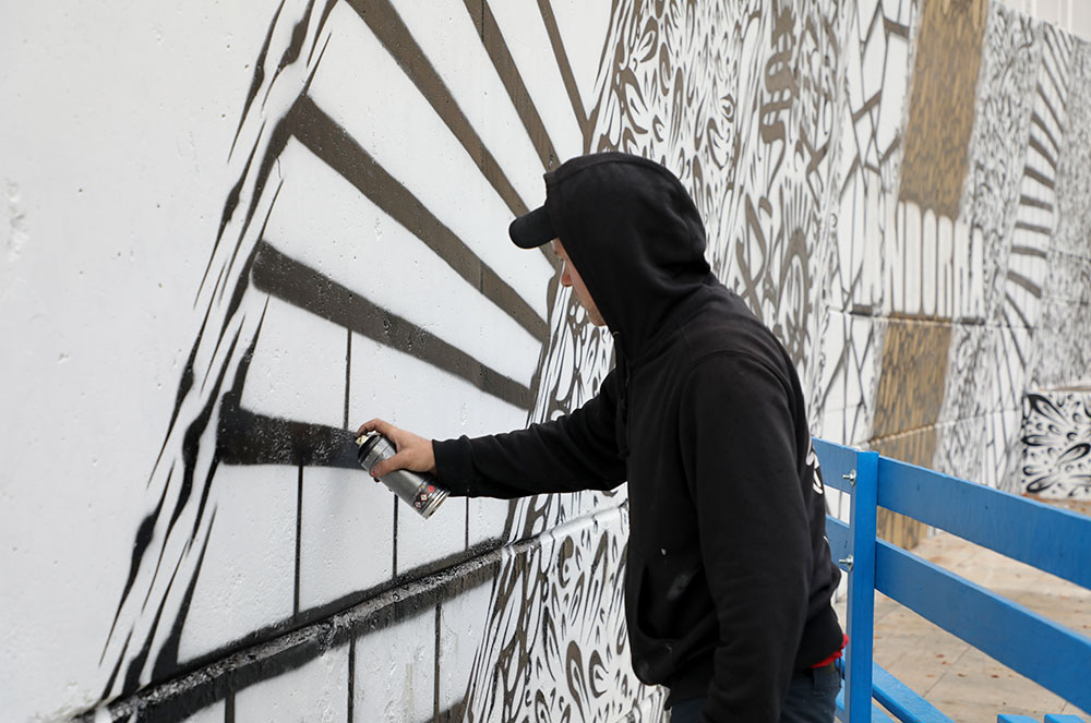 Artista pintant un mural al Prat del Roure